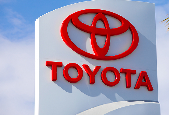 Toyota logo on a white sign against a blue sky background.